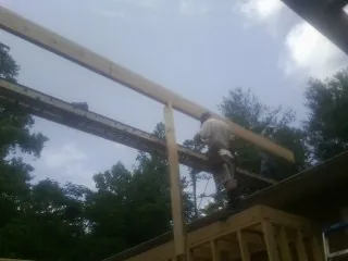 Carpenter setting a ridge beam over a new addition frame — Ice Dam Removal by Roofing Brothers in Fort Loramie
