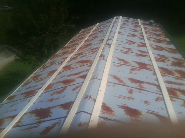 Rusted metal roof panels with new wood purlins before replacement — Storm Damage Roof Repair in Fort Loramie by Roofing Brothers